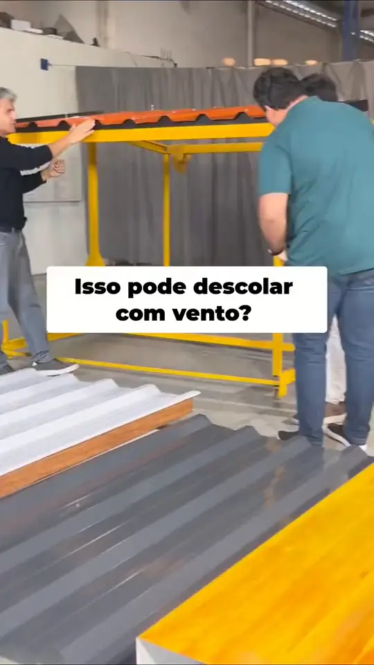 Demonstração de telha sanduíche em balanço sobre estrutura amarela, com a pergunta: isso pode descolar com vento?