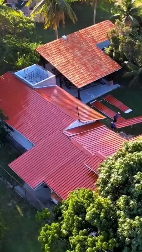 Vista aérea de casa com telhado termoacústico na cor terracota cercada de árvores